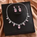 Primo piano dettaglio del set collana e orecchini a goccia in cristallo rosa esposto. - Stile Goccia d'Acqua Rosa (80858341) / Rosa