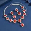 Primo piano dettagliato di un elegante set di collana e orecchini con cristalli rossi. - Argento, Rosso
