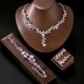 Vista detallada del conjunto de joyas de collar pulsera y pendientes de flores de estrás. - Set de tres piezas / Plata/Púrpura