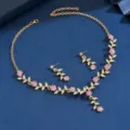 Vista detallada del exquisito conjunto de joyas de collar y pendientes florales dorados. - Juego de 2 piezas / Dorado/Rosa