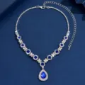 Elegant teardrop crystal necklace detail shot featuring sparkling blue stones and silver chain. - Blue