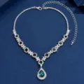 Detailed view of a gorgeous silver rhinestone teardrop necklace with green stone. - Green