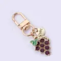 Cute grape keychain alloy fruit bag pendant with purple rhinestones and love charm for keys - Gold Purple Enamel
