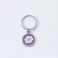 Metal keychain featuring a cute purple floral enamel round pendant stylish accessory gift - Flower Style