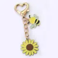 Niedlicher Sonnenblumen- und Bienen-Metallschlüsselanhänger mit goldenem Herzverschluss. - Biene Blume
