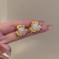 Nahaufnahme Detail der schillernden Perlen Blumen Ohrstecker mit eleganten goldenen Blüten. - Gold