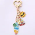 Joli porte-clés d'été mignon avec des breloques en métal voilier et surf de soleil lunettes. - Voilier