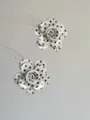 Nahaufnahme von schwarz-weißen Pünktchen-Blumenohrringen mit einzigartigem Lagen-Design. - Wellenförmige Blumenohrstecker / Weiß