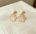 Nahaufnahme Detail von süßen Acryl transparenten Glitzer Bär Ohrsteckern im süßen Stil. - Bär / Orange