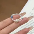 Handmade beaded ring featuring iridescent seed beads, blue square crystal, and baroque pearl. - Clear Blue Crystal Pearl Beaded Rings
