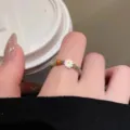 Detailaufnahme eines zarten bunten Perlenrings mit einem niedlichen weissen Gänseblümchen. - Gänseblümchen-Stil