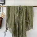 Detailed shot of olive green lace edge scarf with cute bow design for spring and summer chic style. - Green
