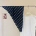 Gros plan d'un foulard triangulaire rayé chic, idéal pour le cou ou la décoration de sac. - Noir