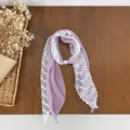 Detailed view of the purple polka dot scarf spliced with delicate white floral lace. - Purple