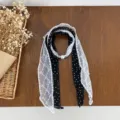 Lace spliced silk scarf detail shot showing the delicate black dot fabric and pearl buckle design. - Black