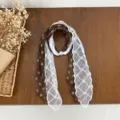 Vintage polka dot silk scarf with delicate white lace stitching and elegant pearl buckle. - Coffee