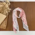 Detail shot of a pink polka dot scarf spliced with white lace and pearl accent, artistic style. - HMS - Sea Ballad Brick Red
