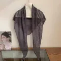 Detail view of the dark grey hollow-out knitted triangle shawl and scarf for women. - Gray