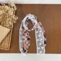 Detail view of brown printed lace patchwork silk scarf with elegant pearl accent for women. - HMS Shadow Floral Plaid - Coffee