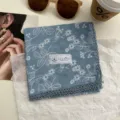Detail van blauwe katoenen zakdoek met bloemenprint en fijne kanten rand in vintage stijl. - Ruyi rankbloemen blauw
