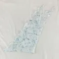 Détail du foulard triangulaire à fleurs, imprimé botanique bleu avec bord laitue. - Nœud de fleur