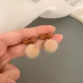 Lindo pendiente de lazo marrón y pompón beige esponjoso, dulce accesorio de invierno. - Pendientes de botón con lazo y pompón marrón