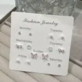 Lindo juego de pendientes semanales con perlas lazos y mariposas para un estilo tierno. - Set de pendientes de botón de mariposa rosa / Rosa
