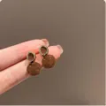 Detail view of French retro caramel glazed metal earrings, showcasing unique glazed texture. - Caramel Geometric Earrings