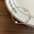Pulsera de cuentas plateada con pequeñas cuentas coloridas y colgante de perla blanca. - Pulseras de una sola perla