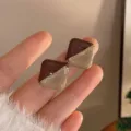 Vista detallada de pendientes vintage franceses estilo Maillard con detalle de cadena. - Pendientes de botón en contraste color café con leche