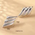 Primo piano di orecchini metallici a strati che mostrano dimensioni precise e peso leggero. - Stile a Strati Ondulati (80119501) / Argento