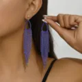 Primo piano di orecchini lunghi con strass blu di tendenza, decorati con cristalli scintillanti. - Argento & Blu (6164)