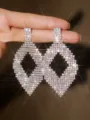 Primo piano di orecchini lunghi geometrici in strass scintillanti, gioielli moda luminosi. - Argento