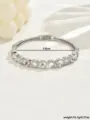 Vista dettagliata del bracciale rigido geometrico in strass argentato con cristalli luminosi. - Argento