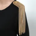 Dettaglio spallina con nappe in catena di metallo dorato, accessorio elegante per abito. - Oro