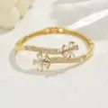Gold tone rhinestone flower bangle bracelet detail view showcasing sparkling crystal stones. - Double Flower Hinge Style (80511302) / Gold