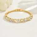 Dettaglio di bracciale rigido geometrico in strass dorato squisito, gioiello di lusso. - Oro