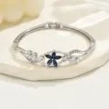 Detailed shot of a silver-tone floral bangle bracelet featuring a dark blue crystal flower. - Dark Blue Crystal Floral Style (80512701) / Silver