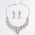 Closeup details of sparkling crystal rhinestone bridal necklace and matching earrings set. - Gold