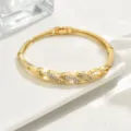Bracciale rigido geometrico in oro con pavé di strass, dettaglio di gioielli di lusso cavi. - Stile Torsione Geometrica (80512202)