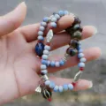 Detail shot of Chinese style beaded bracelet with ceramic beads and lotus pod pendant. - Lotus Pod Pendant Ceramic Bracelets
