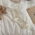 Cute polka dot women's mid-tube socks in cream white, featuring a chic rolled cuff. - White