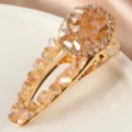 Gros plan sur la pince à cheveux dorée en cristal, ornée de strass champagne étincelants. - S46-3# Pinces bec de canard champagne