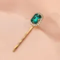 Closeup detail of a gold hairpin featuring a rectangular green crystal and sparkling rhinestones. - Single Stone Clip (S34) / Dark Green