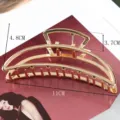 Detail view of a large gold metal hair claw clip with geometric cutout design, elegant fashion. - Semicircle Hollow Geometric Shape (S156-7) / 11cm