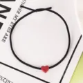 Primer plano detallado de una goma de pelo elástica negra con un colgante de corazón rojo mate. - 6# Coleteros rosas con corazón pequeño