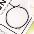Detailansicht eines schwarzen Haargummis mit mattem grünen Herzanhänger, süßes Accessoire. - 2# Grüne Haargummis mit kleinem Herz