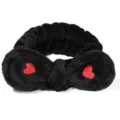 Nahaufnahme des schwarzen Plüsch-Haarbands mit roter Herzstickerei, weiches Kosmetikband. - Schwarzes Herz