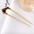 Detail shot of a minimalist U-shaped hair fork with matte metal and stylish acetate top. - 10.9cm / Tortoise