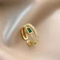 Vista detallada de un anillo abierto de circón verde retro con cristales brillantes y acabado dorado. - Dorado Letra G